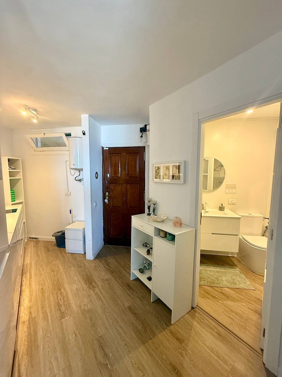 Hallway with the wooden front door and the open bathroom door