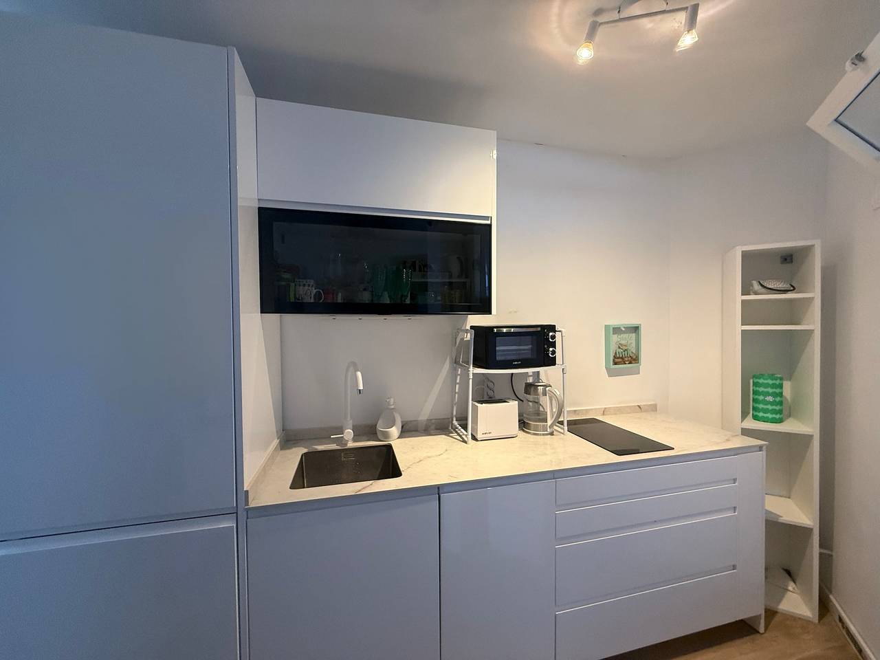 Kitchen counter with sink, microwave, toaster and cooktop