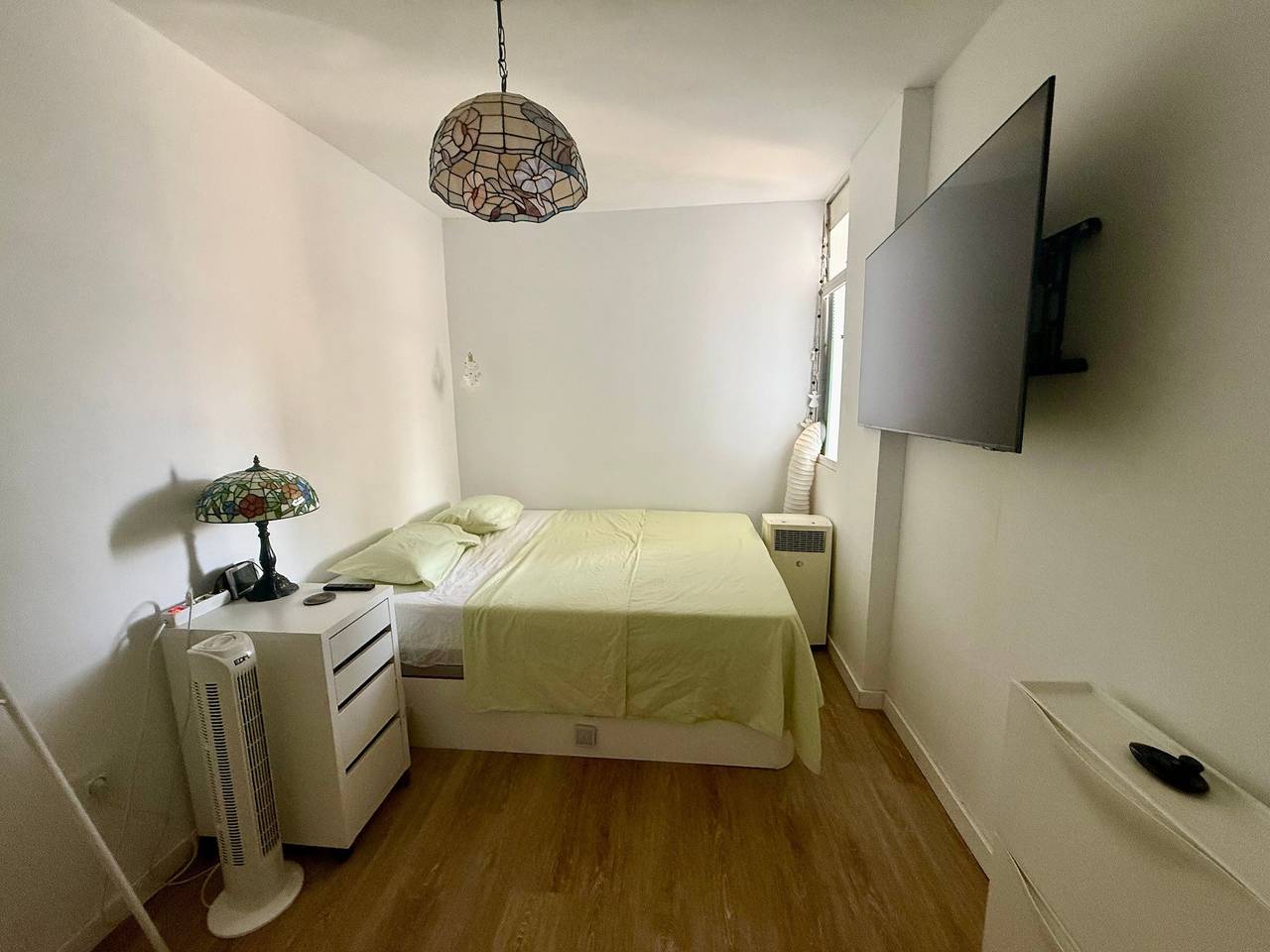Bedroom with double bed, bedside table and wall-mounted television